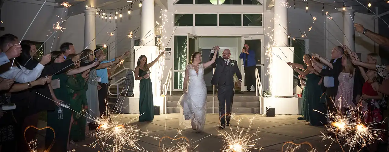 bride and groom leaving the White Chapel at night surrounded by guests